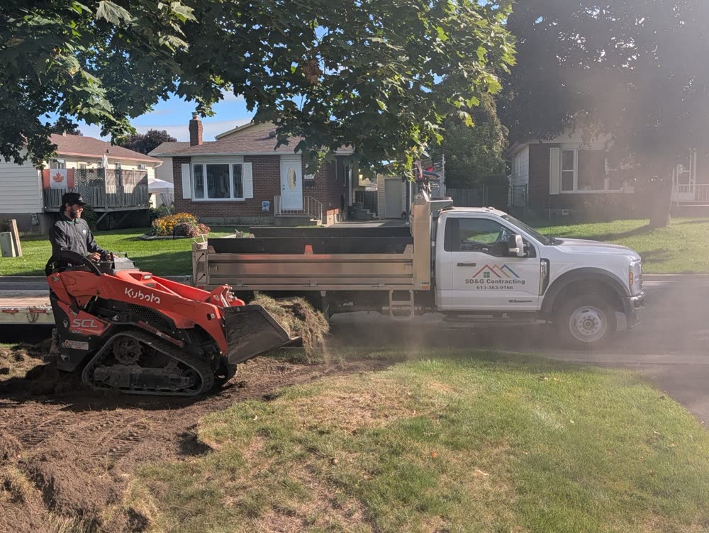 Track loader dumping stripped sod into the SD&G Contracting dump truck