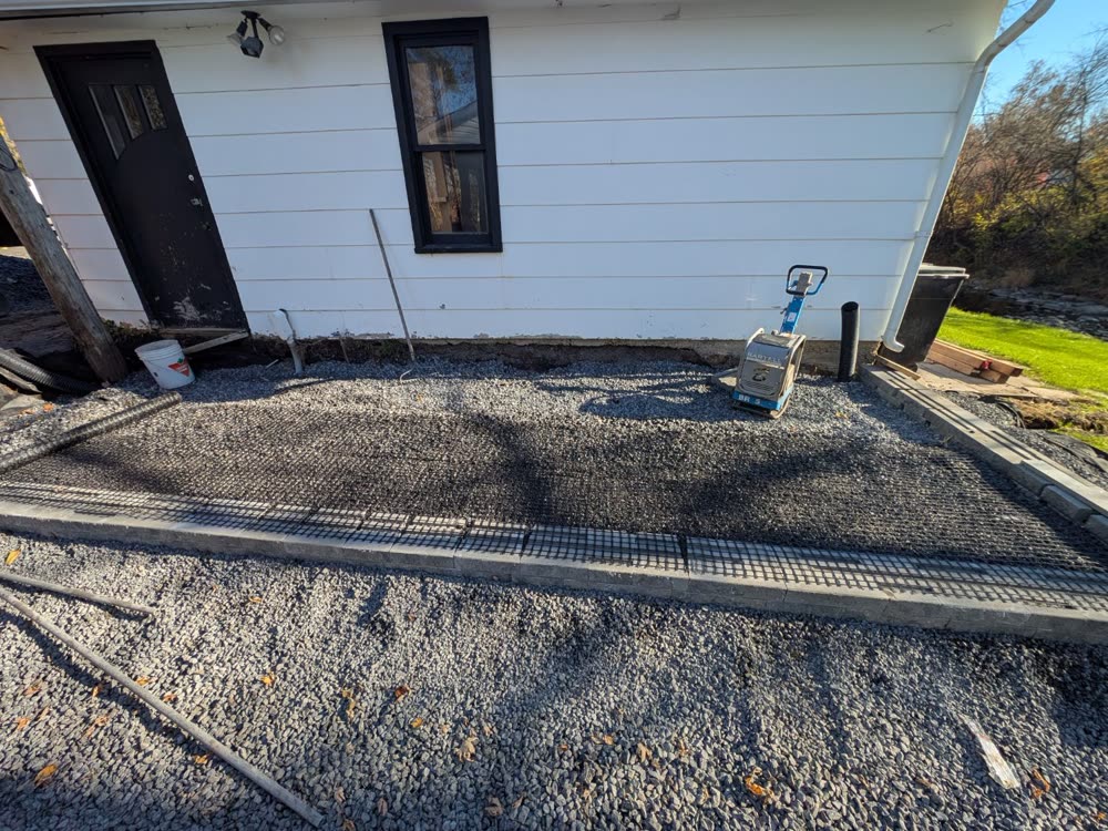 Geogrid reinforcement laid over the compacted stone base behind the wall block
