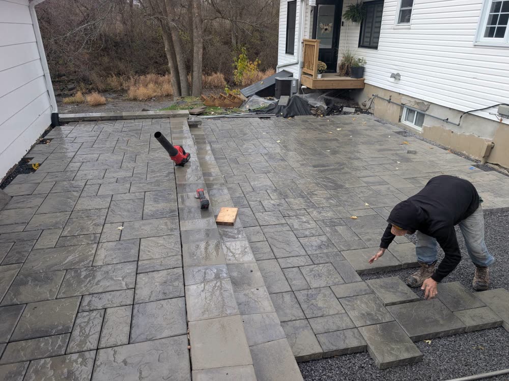SD&G crew member laying large-format interlock slabs on the prepared base
