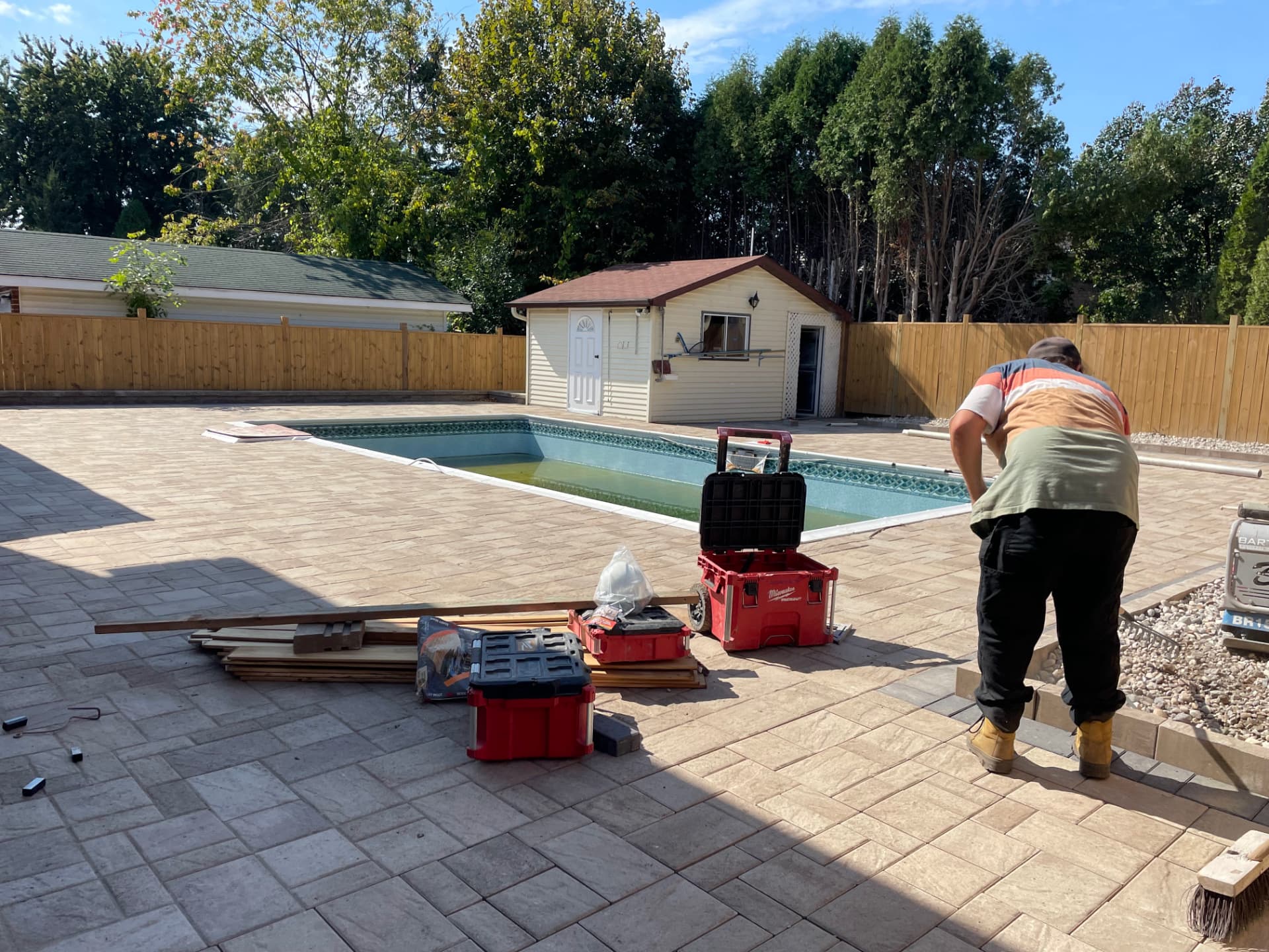 Interlock pavers being laid around an in-ground pool in Cornwall