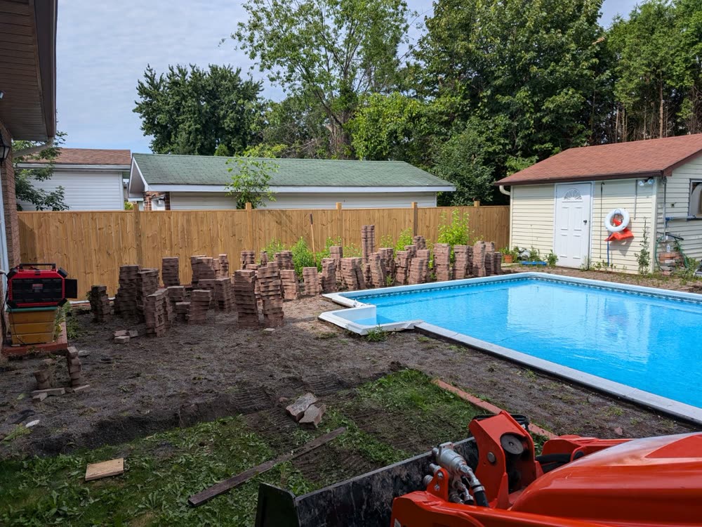 Old pavers stacked after being lifted from around the pool